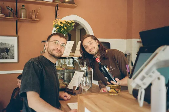 Two smiling baristas behind the counter