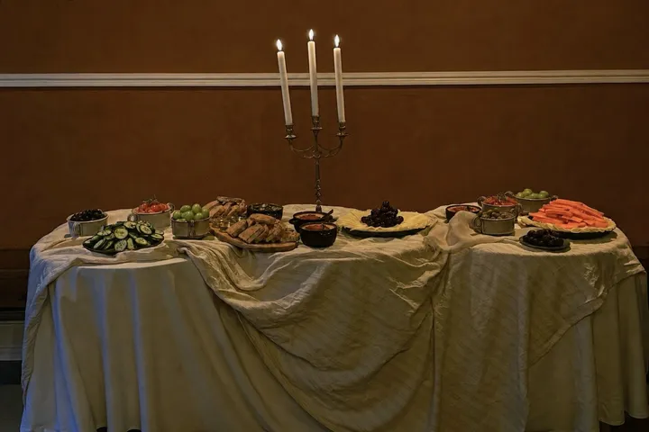 A long candlelit table set for a private dinner