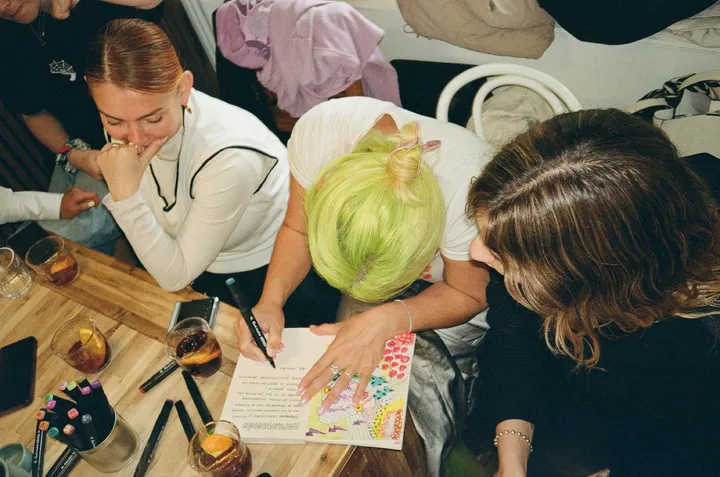 Friends drawing together around a table at a workshop