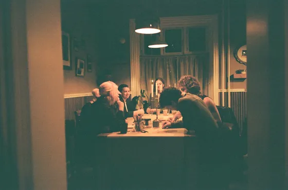 A dinner gathering seen through a doorway
