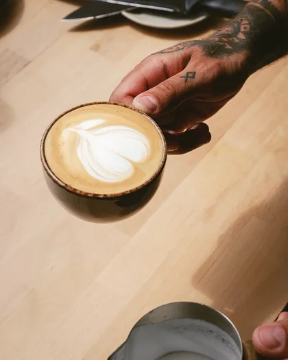 A flat white held over the counter